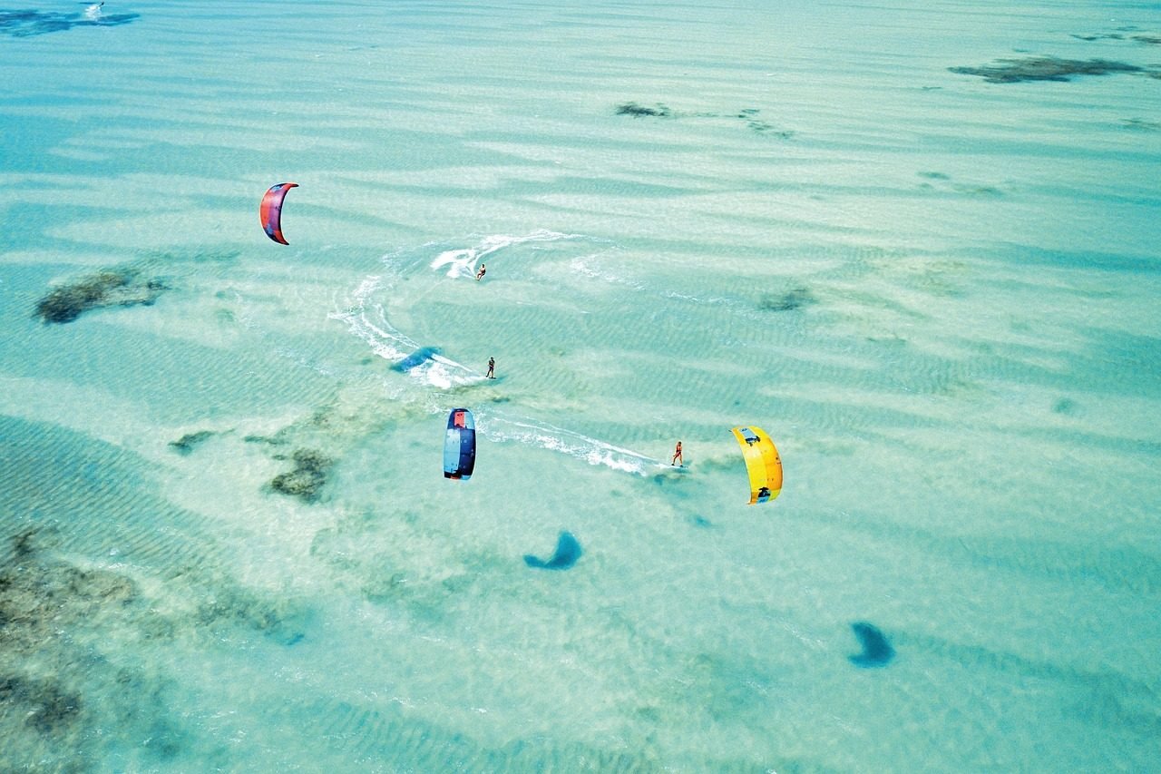 Kite surfers crossing a turquoise Zanzibar lagoon